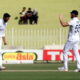 Two England cricketers celebrate during a Test match, one appealing after a delivery as the other supports from the field.