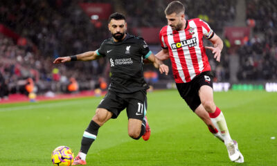 A Liverpool player competes for the ball with a Southampton player during a Premier League match.